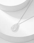 Natural clear quartz pavé teardrop pendant necklace on silver cable chain, white background
