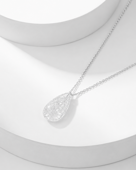 Natural clear quartz pavé teardrop pendant necklace on silver cable chain, white background
