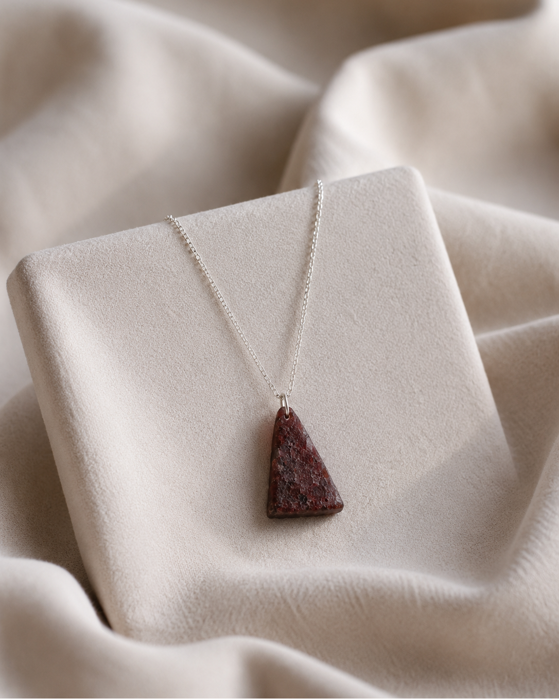 natural red stone triangle pendant necklace on display rex stones