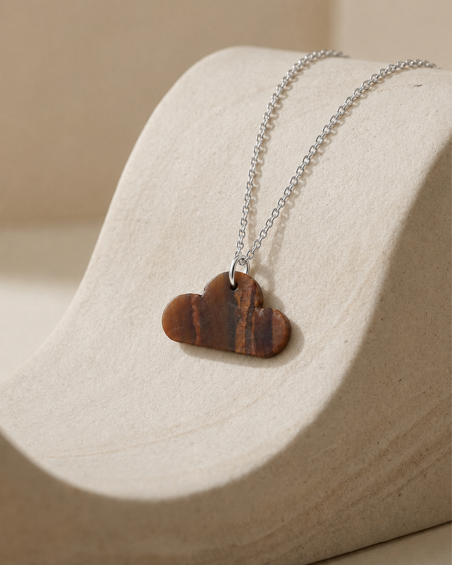 Natural Tiger Eye cloud pendant necklace on silver chain, beige display stand