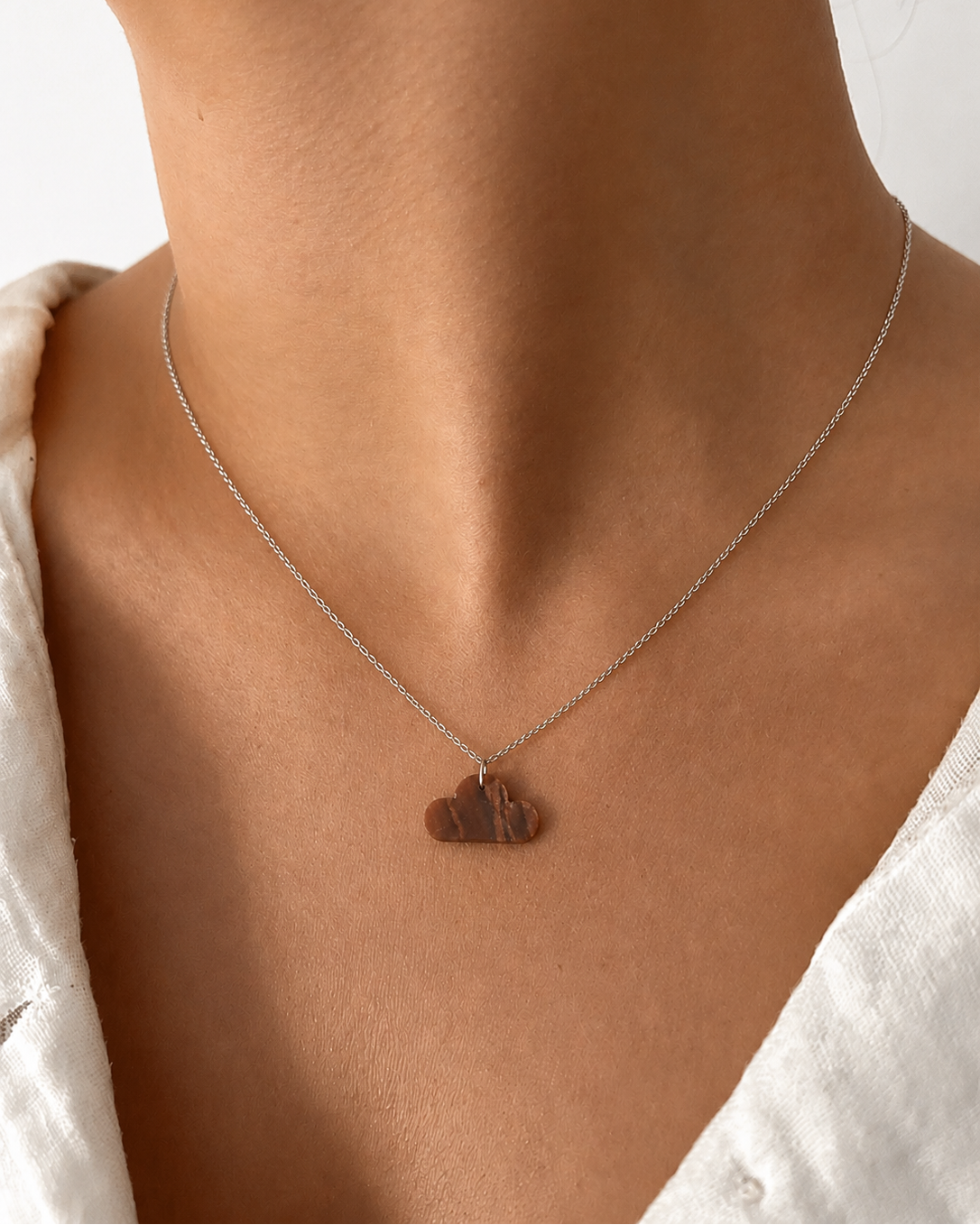 Model wearing natural Tiger Eye cloud pendant necklace, close-up front view