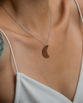 Model wearing natural Tiger Eye crescent moon pendant necklace, white top