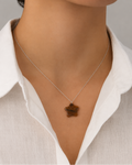 Natural Tiger Eye star pendant necklace on silver chain over white fabric