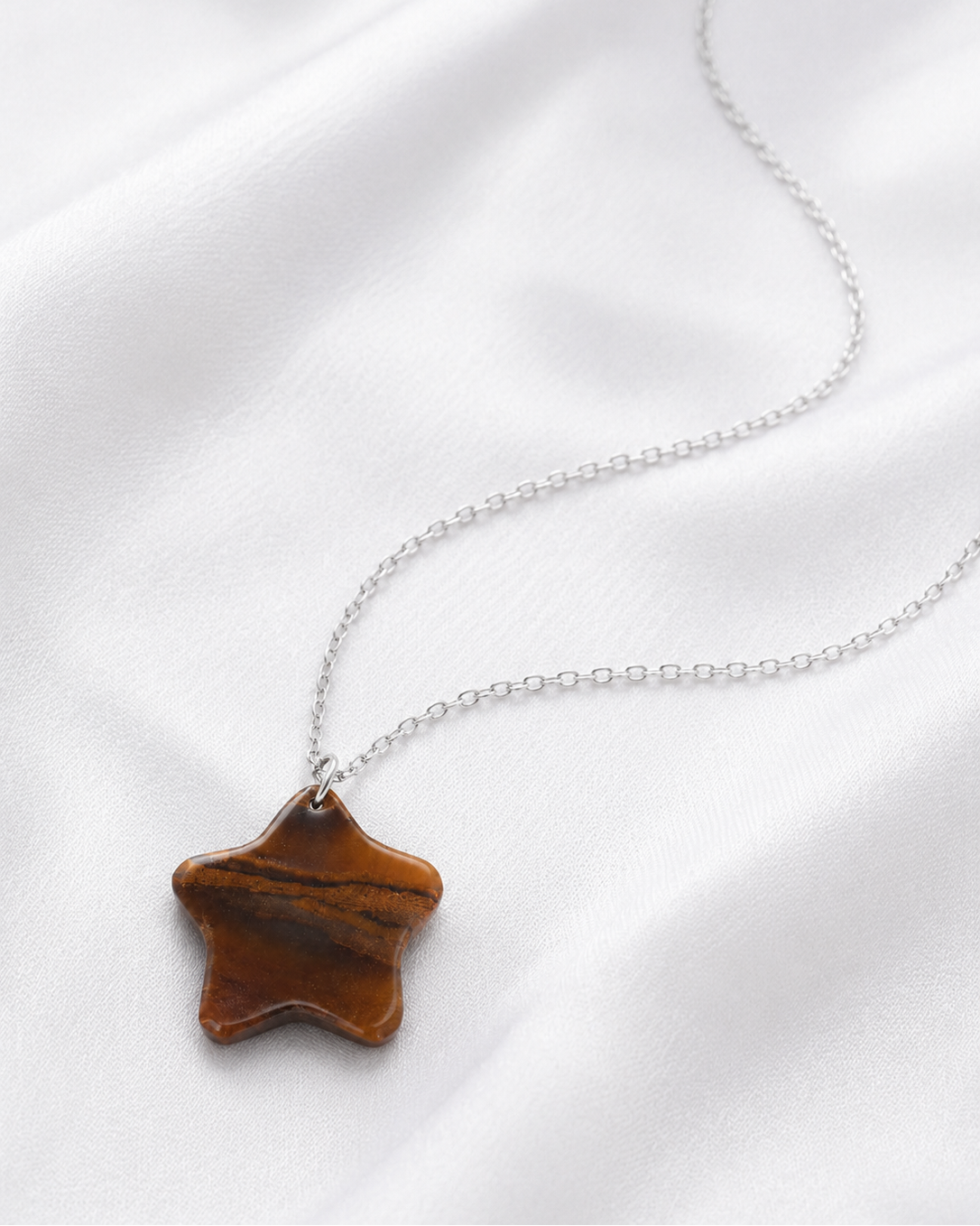 Model wearing natural Tiger Eye star pendant necklace with white shirt, close-up