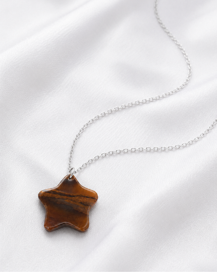 Model wearing natural Tiger Eye star pendant necklace with white shirt, close-up