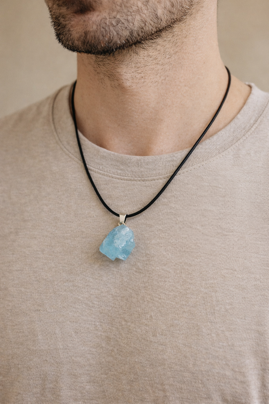 person wearing raw aquamarine pendant minimal jewelry