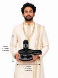 Hand-carved 0.5 ft Third Eye Shiva Lingam statue in polished black stone shown with an adult model for scale and measurements.