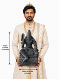 Hand-carved 1.25 ft Agastya Maharishi statue in polished black stone shown beside an adult model for scale.