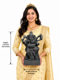 Hand-carved 1.25 ft dancing Nritya Ganesha statue in polished black stone shown beside an adult model for scale.
