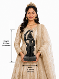 Hand-carved 1.5 ft Madurai Veeran guardian deity statue in polished black stone shown with an adult model for scale.