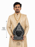 Hand-carved 1 ft Gangai Amman Sirasu statue in polished black stone shown with an adult model for scale and measurements.