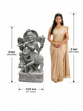 Hand-carved 4 ft Venugopala Krishna statue with cow in polished black stone shown beside an adult model for scale.