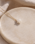 close up of white moonstone star pendant on gold chain showing natural texture